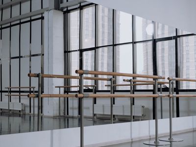 Empty bright workout studio with large windows and mirrors.